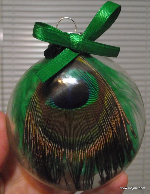I glued a Peacock feather and a couple accent feathers on the inside of a clear glass ornament.  A small bow accents the piece.    These are the cutest Christmas tree ornaments, EVER! Okay, I am a little biased. 