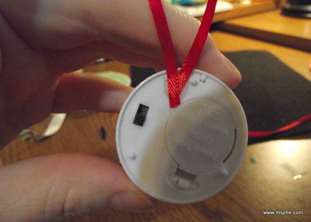 I glued some ribbon onto the back of the tea light. It's important to avoid the battery case and the on/off switch.