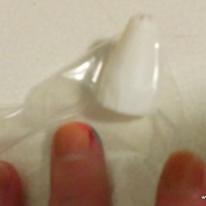 Cut a VERY small hole into the corner of a ziplock baggy. Poke your cake tip through only 1/3 of the way. Sorry for the bad photo, maybe I'll post a different one later. 